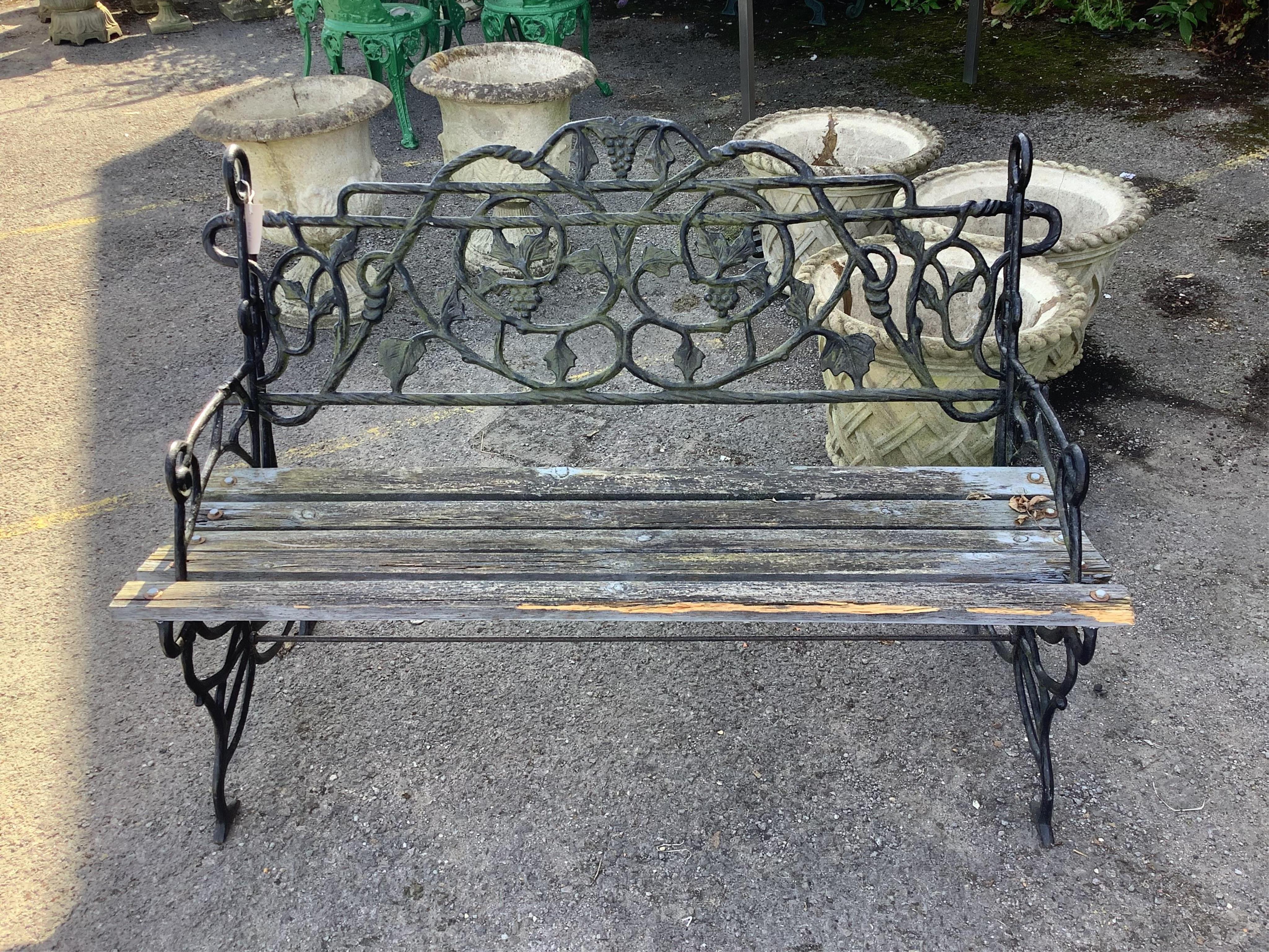 A Victorian style cast iron slatted garden bench, width 106cm, height 76cm. Condition - poor